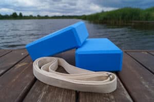 yoga blocks and strap on a dock at a lake